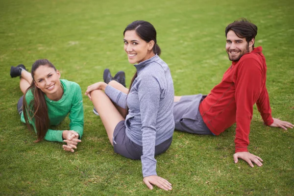 锻炼的伙伴和朋友 穿着运动服坐在草地上的年轻人的画像 — 图库照片