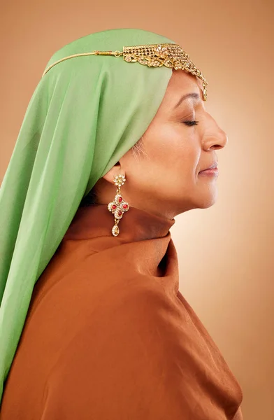 茶色のスタジオの背景に対して宝石 信仰とヒジャーブを持つイスラム教徒 文化服やシニア女性 精神的 スカーフとイスラムファッション 伝統的で控えめなブルカモデル — ストック写真