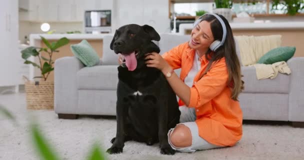 家の中で動物やペットの所有者ケアと黒犬 女性とリビングルーム 幸福と笑顔で家の中で子犬の愛と音楽を聴く家の中でヘッドフォン ジェンZ人とラブラドール — ストック動画