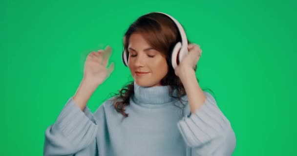 Kadın Dans Kulaklıklar Yeşil Bir Stüdyoda Gülümseyerek Müzik Dinliyor Kulaklıklı — Stok video