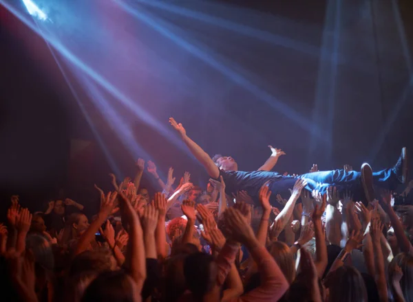 载歌载舞的是歌迷 在摇滚音乐会上 舞台上的一个跳水者被抬过观众中间 — 图库照片