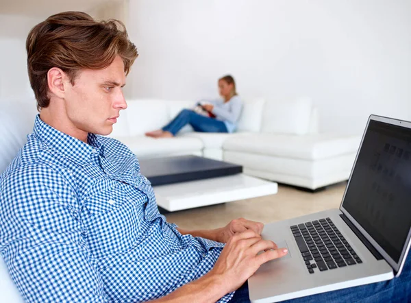 被技术分开了一个年轻人坐在电脑屏幕上 而他的女朋友坐在后面 — 图库照片
