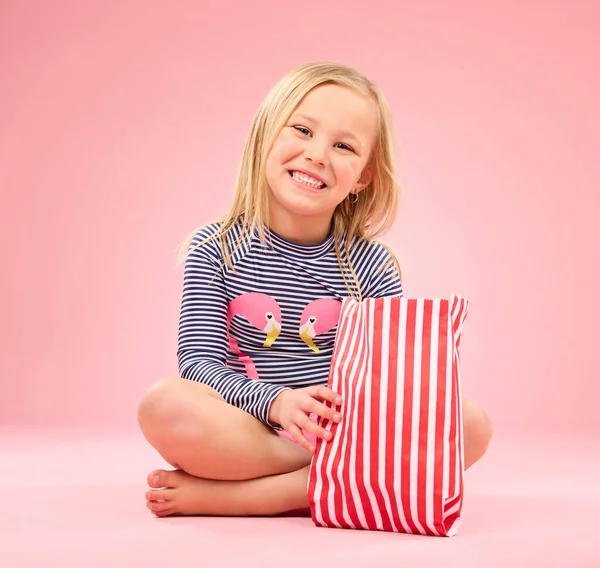 爆米花 食物和快乐的女孩肖像画在一个粉红背景的工作室里 与电影小吃坐在一起 带着纸袋和薯片的小点心 快乐和饥饿的孩子带着微笑吃饭和感觉放松 — 图库照片