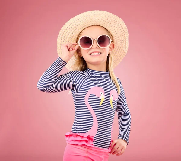 带着太阳镜和帽子的快乐孩子的肖像在工作室里 穿着有趣的衣服 背景是粉色的 假日和时尚界 澳大利亚女孩都对旅行感到兴奋 脸上挂着笑容 — 图库照片