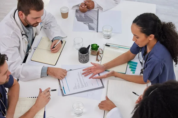 Above discussion of medical teamwork, meeting or paperwork report of test results at table. Diversity, hospital doctors and healthcare documents of research, surgery analysis or planning clinic notes.