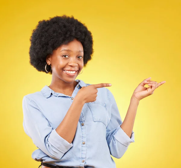 快乐的 一个黑人妇女的肖像在工作室指向模仿空间的广告或营销 微笑和非洲女性模型 按黄色背景显示产品放置的模型 — 图库照片