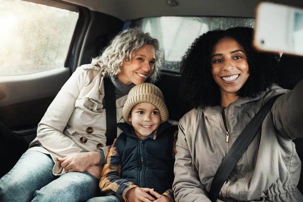 stock image Selfie, smile and family on a road trip in a car for bonding, quality time and a getaway together. Happy, travel and mother, grandmother and a child taking a photo on vacation for social media.