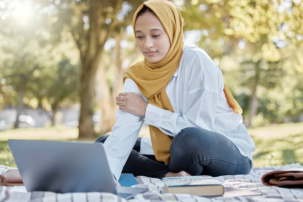 Muslim, student and woman with laptop in park for elearning, studying or knowledge research. Islamic college, education scholarship and female with computer for internet browsing in university campus.