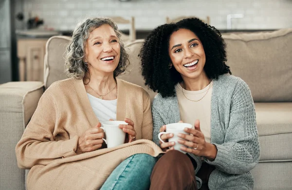 stock image Love, mother and adult daughter on floor, coffee and quality time in living room, happiness and relax. Family, female child or mama with tea, smile or loving together in lounge, rest and conversation.