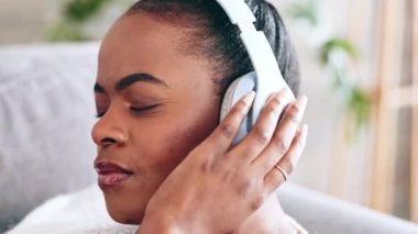 Rahat ol, müzik ve siyah kadın, radyo, podcast ya da ses için kulaklıkları olan koltukta. Huzur, stres atma ve Afrikalı kadın sakin bir parça dinliyor, kanepede şarkı kaydediyor ya da eğleniyor..
