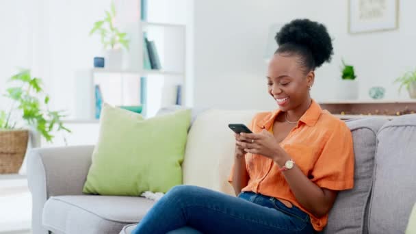 快乐而又黑的女人躺在沙发上 一边在客厅里一边打字一边发短信 沟通和非洲女性在社交媒体或互联网上使用手机建立网络联系 — 图库视频影像