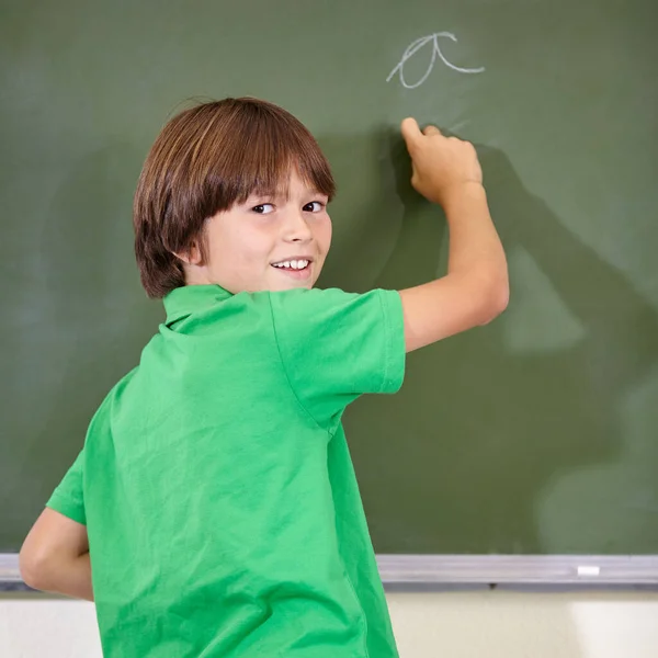 手書きの練習だ 学校の授業中に黒板に文字を書く男の子 — ストック写真