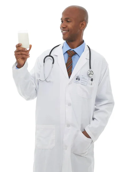 Recommended by a healthcare professional. A handsome male doctor holding a glass of milk