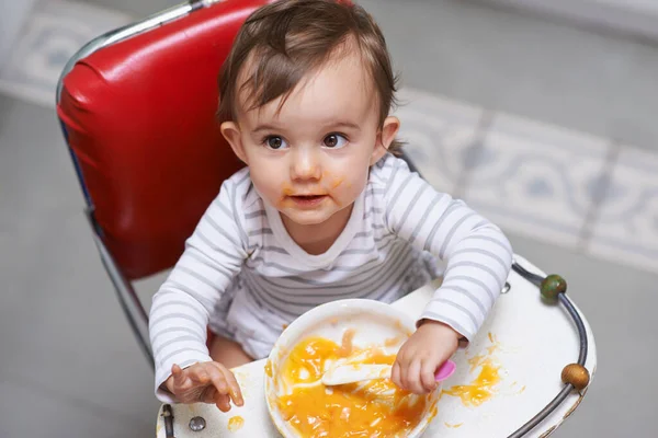 探索新的品味 一个可爱的小宝宝坐在高椅子上吃着固体食物 — 图库照片