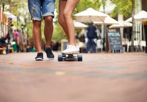 それを一度に1回乗ります スケートボードで1つのバランスを持つ若いカップルの足 — ストック写真