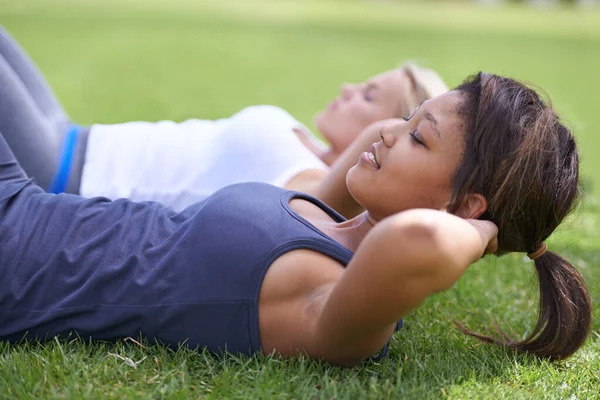 腹筋を働かせろ 若い女性は外の草の上に座り — ストック写真