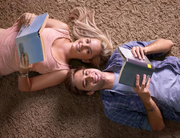 用他们的学习材料放松 两个大学生躺在地板上看书的画像 — 图库照片