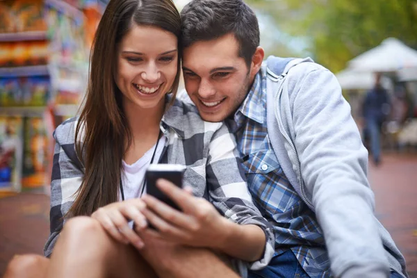 享受移动摄影的舒适性 一个快乐的年轻女人用智能手机给男朋友看点东西 — 图库照片