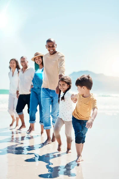 ウォーキング 肖像画 大きな家族がビーチで手をつないで散歩 絆を深め 遊んでいます スペインの休日に祖父母と両親と一緒に海で愛 屈託のない子供たち — ストック写真
