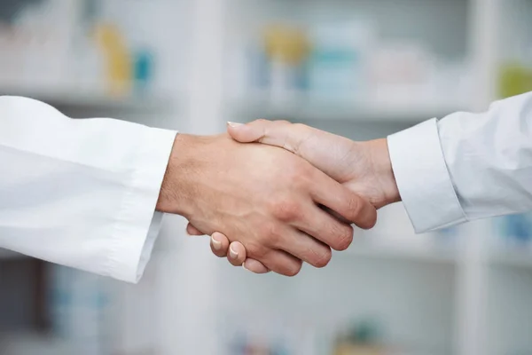 Doctor, handshake and partnership in support at pharmacy for healthcare success, promotion or deal at clinic. Medical expert shaking hands in teamwork for life insurance, b2b or pharmaceutical needs.