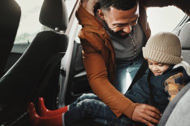 Baba, emniyet kemeri takıp tatile, yolculuğa ya da tatile çıkan çocuklara yardım et. Ulaşım, baba ya da aile hafta sonu için çocuk ya da çocuk taşıyan mutlu bir ebeveyn..