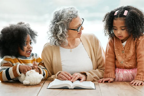 Bible, reading book or grandma with children for worship, support or hope in Christianity for education. Kids siblings, grandmother or old woman studying, praying or learning of God in religion.