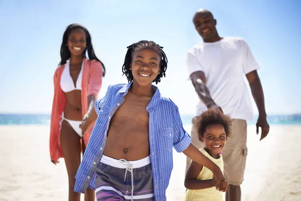 Leading the way. An african-american family enjoying a day at the beach together