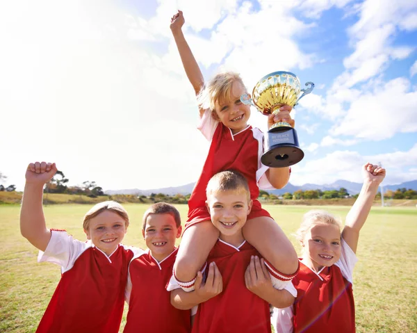 庆祝我们的胜利拿着奖杯的儿童足球队 — 图库照片