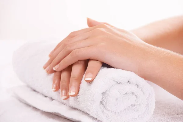 Manicured nails. a womans hands resting on a towel