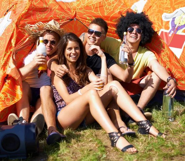 彼らの若者を祝う テントの外に座って笑っている4人の若い友人の肖像画 — ストック写真