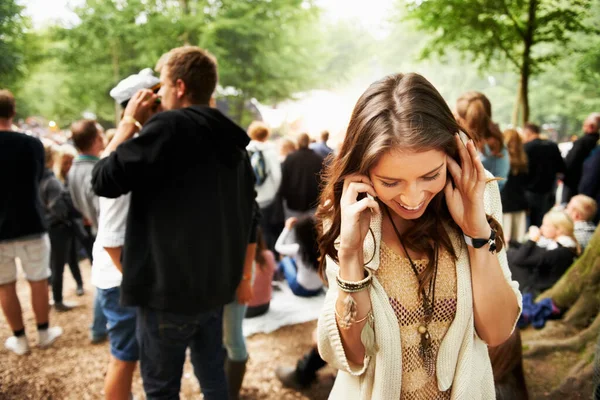 急いでこの場所は素晴らしいです 野外フェスティバルでスマートフォンを聞こうと奮闘する若い女性 — ストック写真