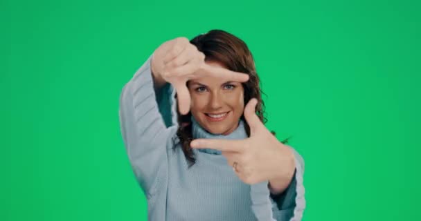 緑の画面や写真撮影のためのクロマキーの背景に顔のための女性 手とフレーム スタジオクロマキーを背景に指で顔の表情をフレーミングする女性の肖像画の手 — ストック動画