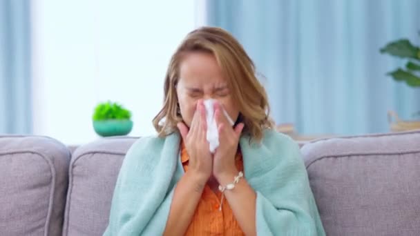 風邪で自宅で組織と鼻や女性を吹いて インフルエンザや病気 アレルギー ウイルスや病気 家の中で熱や副鼻腔炎を持つリビングルームでソファの上にCovid トイレットペーパーや女性のくしゃみ — ストック動画
