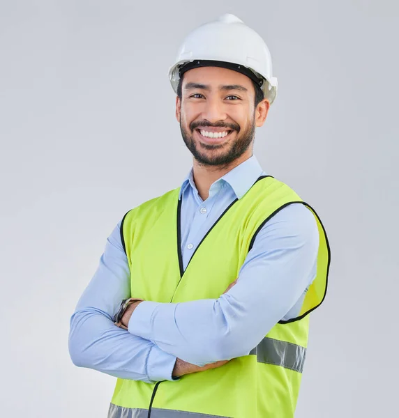 Construction worker, engineer and studio portrait of happy man in vest and helmet for safety on white background. Smile, contractor or architect in planning or renovation, project manager in India