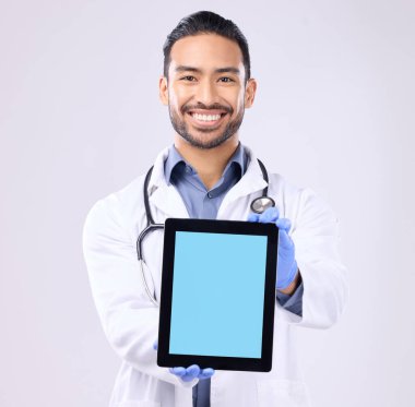 Tablet, yeşil ekran ve doktor portresi beyaz arka plan teknolojisiyle izole edilmiş tele-sağlık servisi modeli. Dijital uygulaması olan tıbbi profesyonel ya da sağlık Asyalı adam stüdyoda yer kaplıyor..