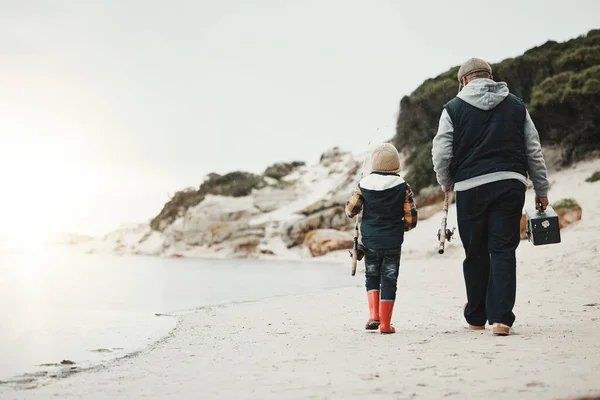 Bonding, back and child with grandfather for fishing, recreation and learning to catch fish at beach. Morning, holiday and boy on walk by the sea with elderly man for a new hobby together on mockup.