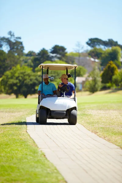 享受一个阳光灿烂的白天游戏 两个朋友在阳光灿烂的日子开车送高尔夫球场 — 图库照片