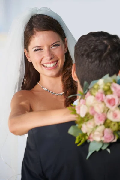 爱他们的婚礼日 一个高兴的年轻新娘捧着一束花拥抱丈夫的画像 — 图库照片