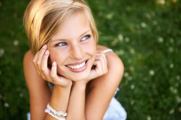 她喜欢夏天的时光 迷人的金发女子坐在外面的草地上 微笑着 — 图库照片