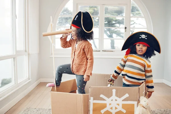 Pirate, box and games with children in living room for playful, creative and imagine. Fantasy, relax and party with kids sailing in cardboard boat at home for free time, weekend and entertainment.