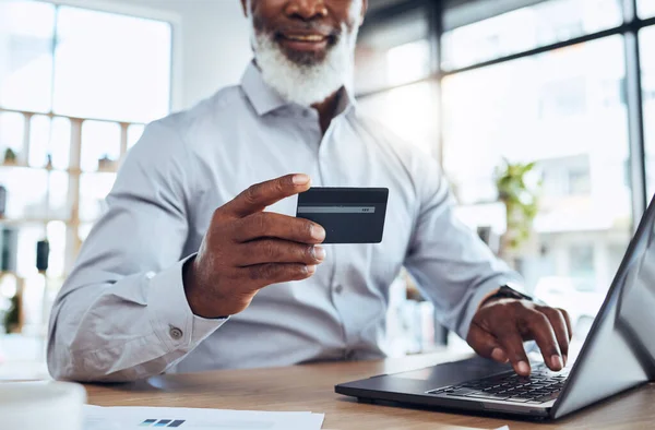 Hands of black man, business credit card and laptop for ecommerce, finance or accounting in office. Worker, computer and financial payment of budget, fintech trading or banking of investment economy.