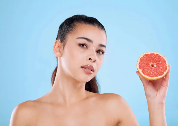 stock image Have you tried grapefruit. Studio portrait of an attractive young woman posing with half a grapefruit against a blue background