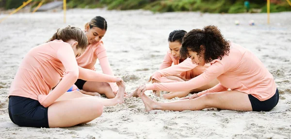 ビーチ バレーボールや女性の試合 競争やスポーツゲームをプレイする準備ができて足をストレッチ チームワーク フィットネス 女性選手が体を伸ばして体を暖め 砂の上で練習し 訓練し 運動する — ストック写真