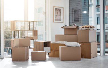 An apartment waiting to become home. boxes in a new and empty home during the day clipart