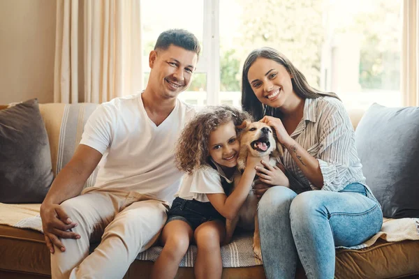 stock image This is our little family. a young family sitting on the sofa at home and bonding with their dog