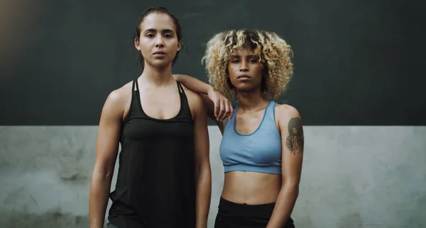 Becoming stronger, fiercer and more powerful. Portrait two sporty young women standing together in a gym