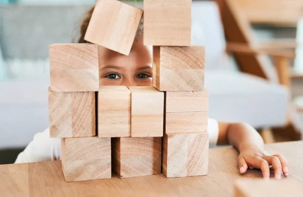 stock image I see you. Portrait of an adorable little girl playing with wooden blocks at home