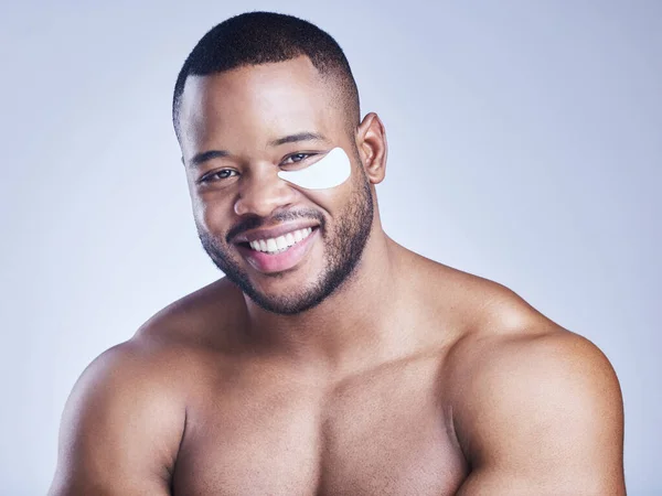 stock image First I de-puff then I get things done. Studio shot of a handsome young man wearing an under eye patch against a blue background