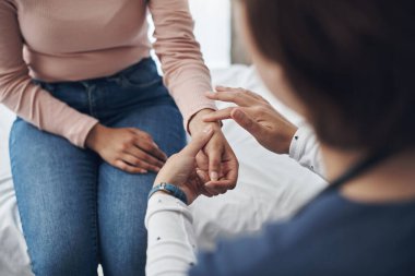 Acıyor mu? Ofiste hastaların bileklerini kontrol eden tanınmayan bir doktor.