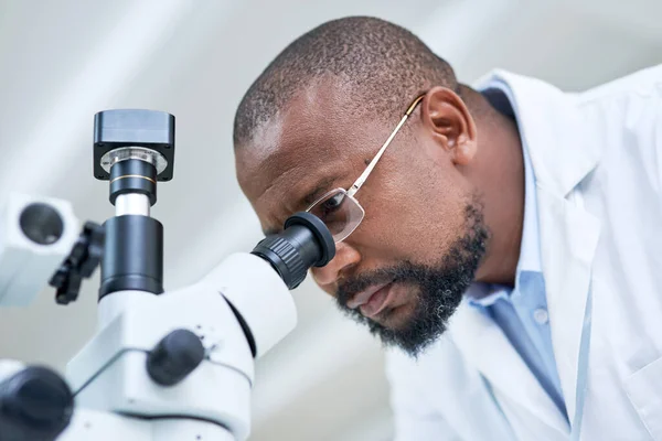 Scientific research is a critical tool for navigating our complex world. a mature scientist using a microscope in a lab